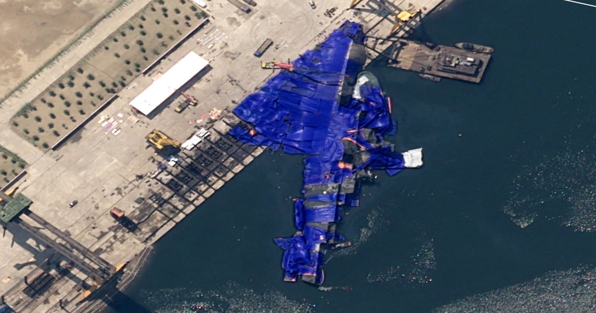 A North Korean destroyer after a failed launch. It has been covered with blue tarps.